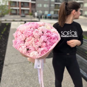 A large, lush bouquet of vibrant pink peonies, their delicate, ruffled petals creating a stunning display of floral elegance. Delivered fresh to your door in Calgary.