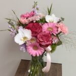 Roses, herbera and orchids, bouquet in a vase.