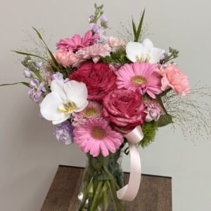 Roses, herbera and orchids, bouquet in a vase.
